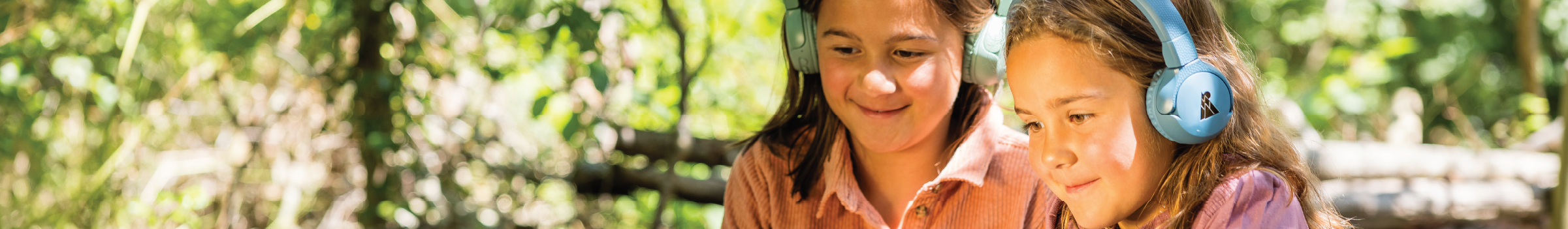 Two girls wearing POGS headphones outside