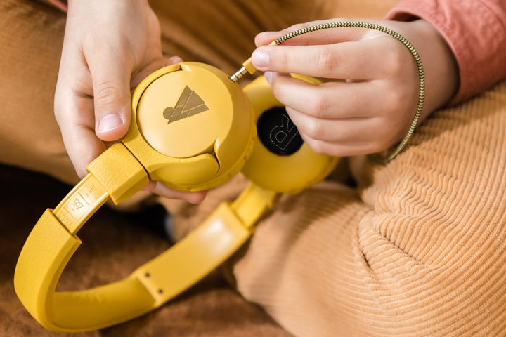 Boy inserting audio cable into POGS headphones